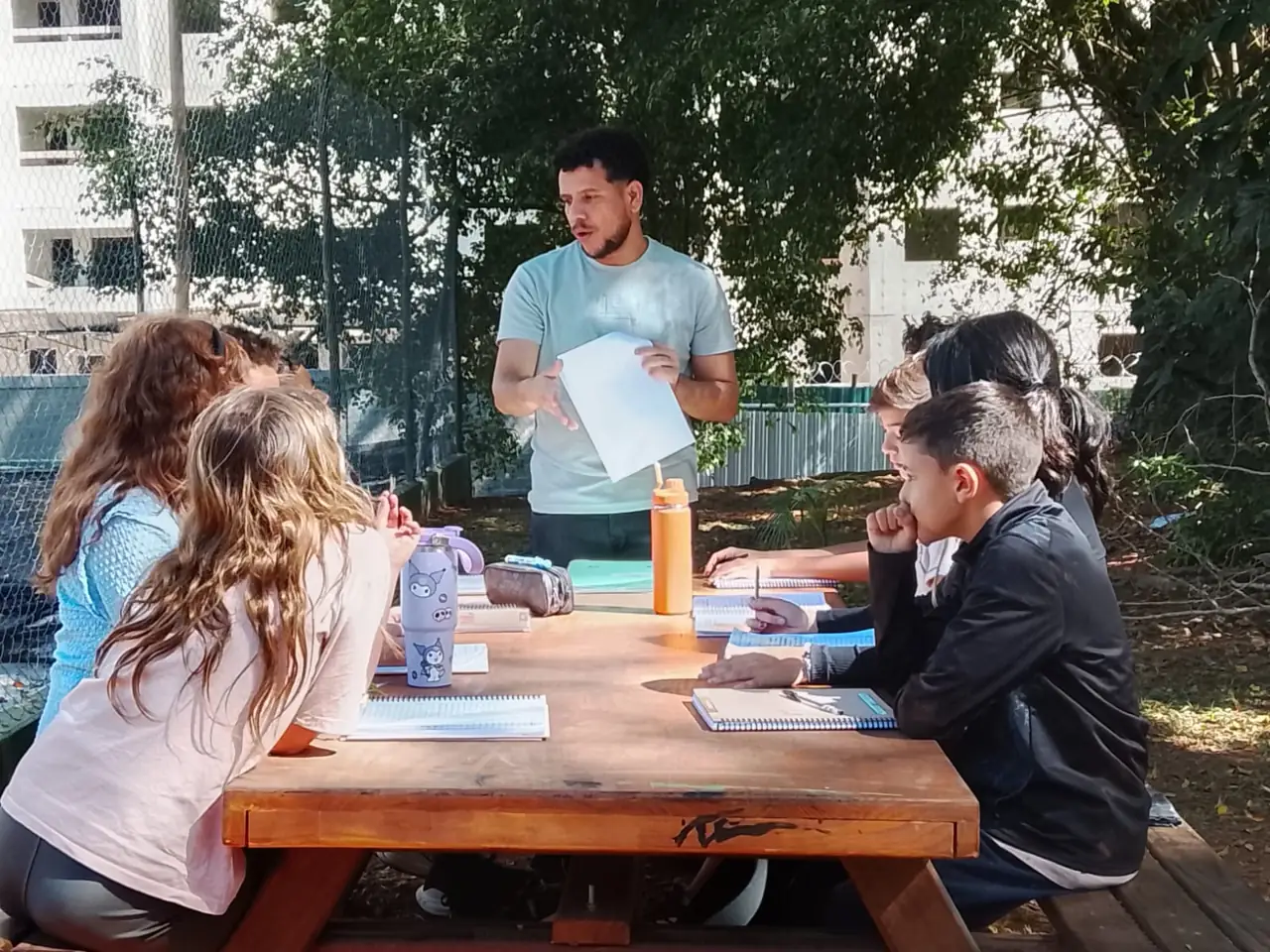 Professor do MOVA conduzindo aula ao ar livre com estudantes